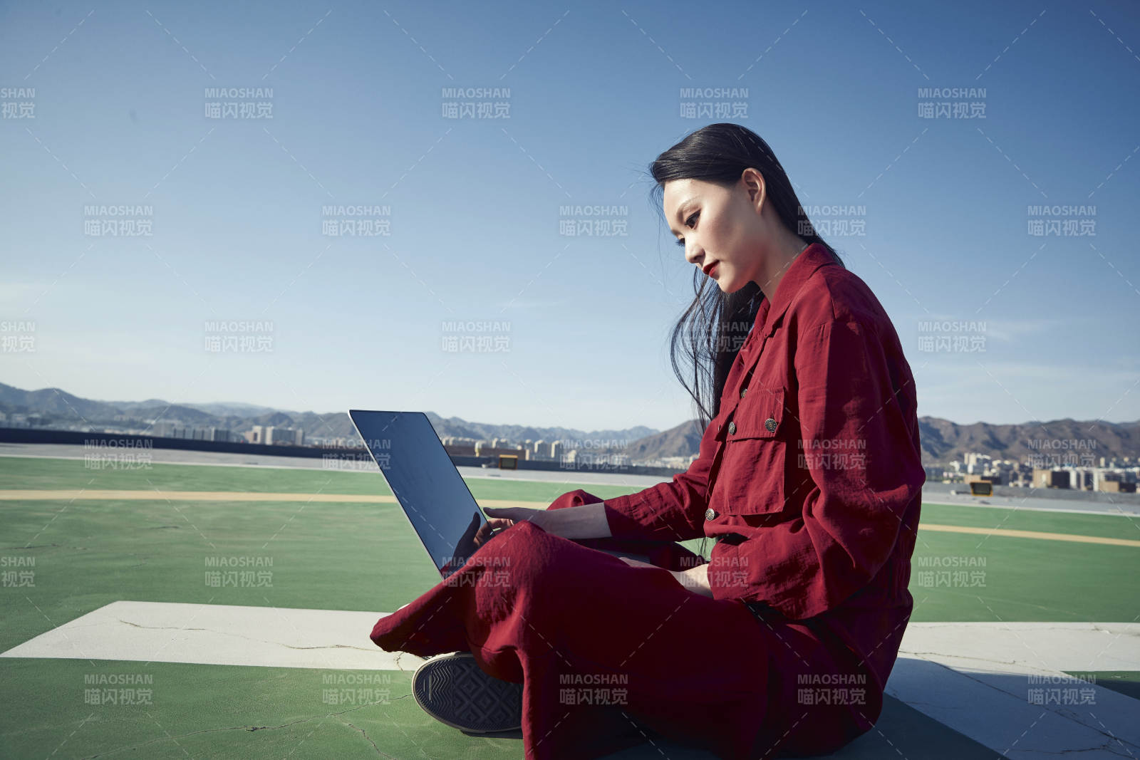 亚洲商务年轻女性在楼顶停机坪使用电脑办公图片