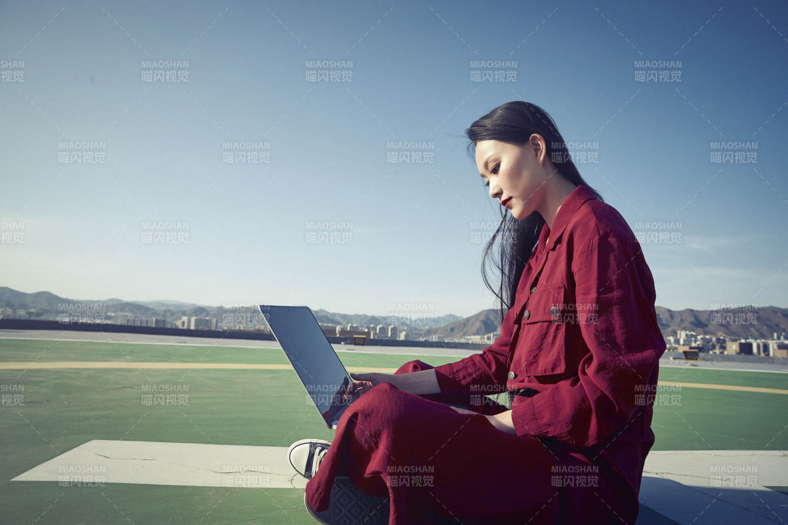 亚洲商务年轻女性在楼顶停机坪使用电脑办公图片