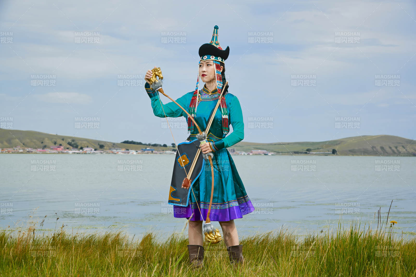 草原湖畔身穿蒙古族饰手持弓箭的蒙族少女图片