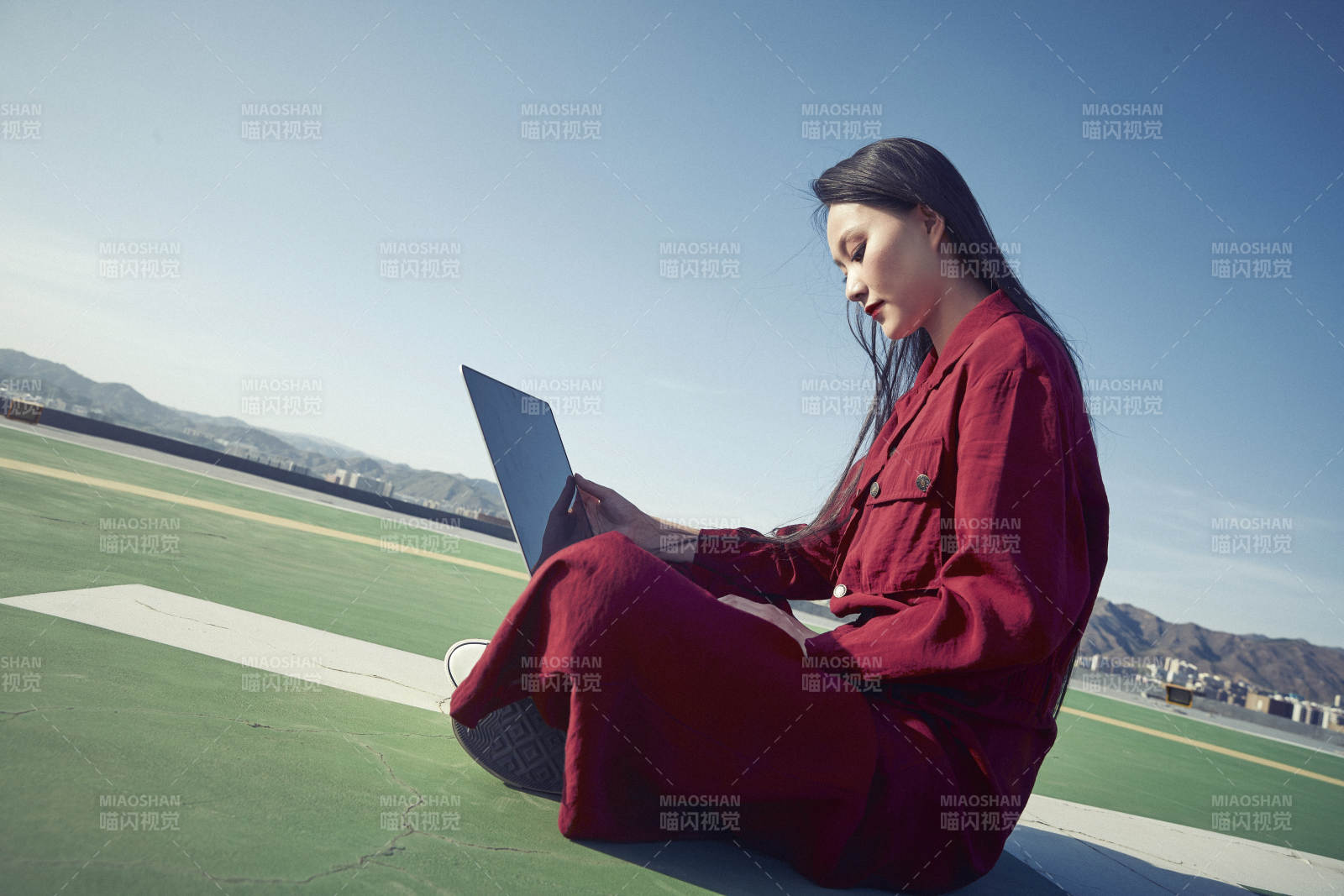 亚洲商务年轻女性在楼顶停机坪使用电脑办公图片