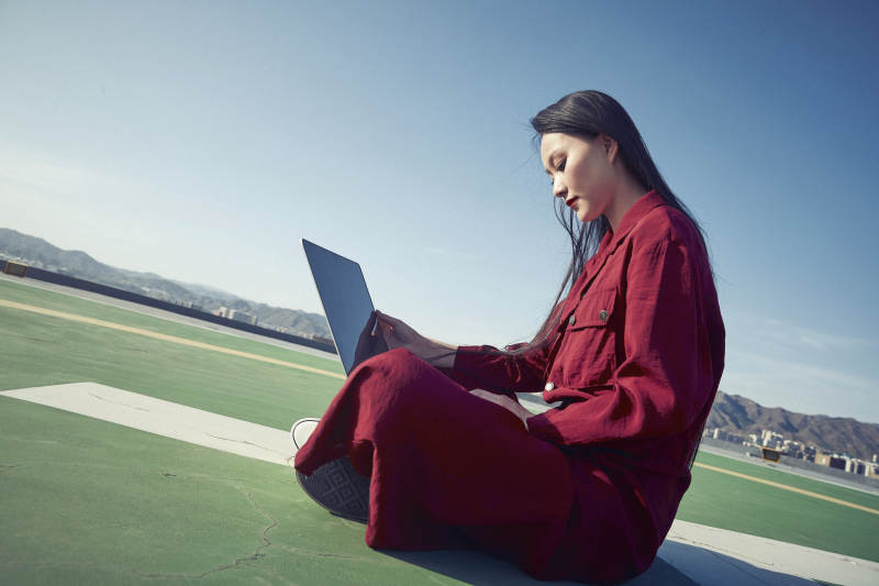 亚洲商务年轻女性在楼顶停机坪使用电脑办公图片