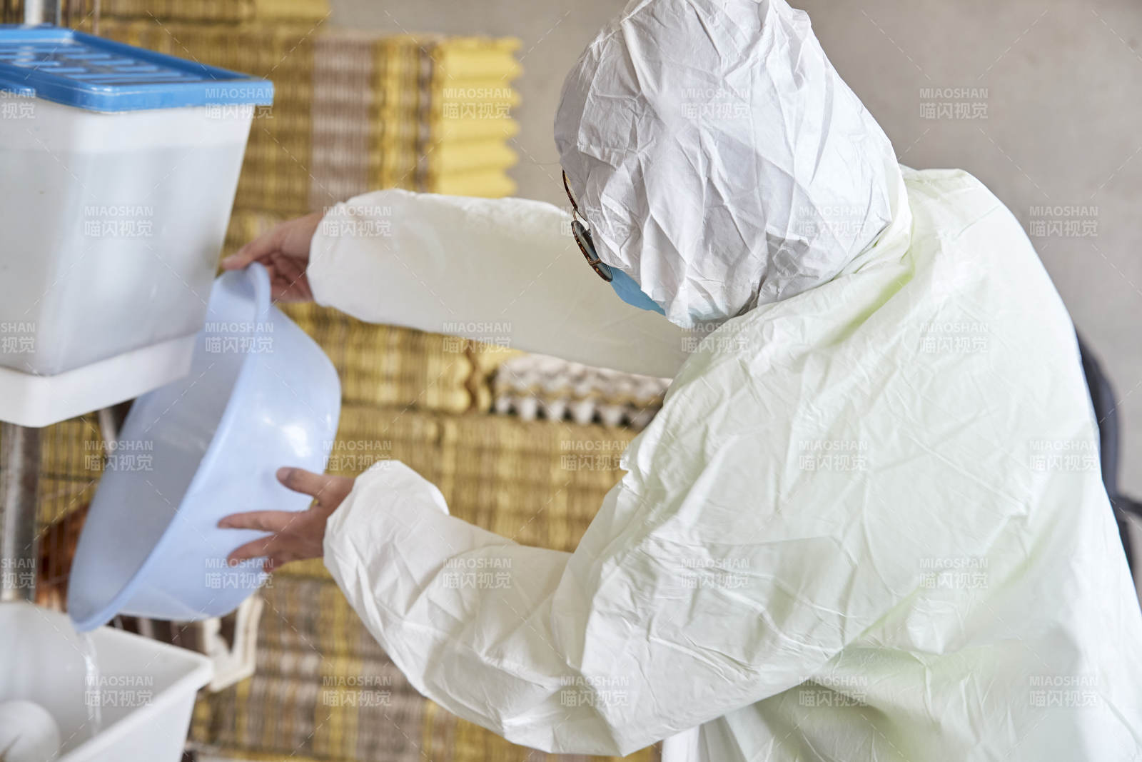 身穿防护服展示油鸡蛋的女性饲养员图片