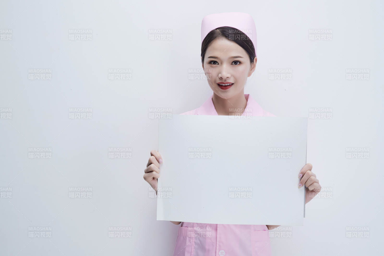 身穿粉色护士服佩戴听诊器的女性医护人员图片