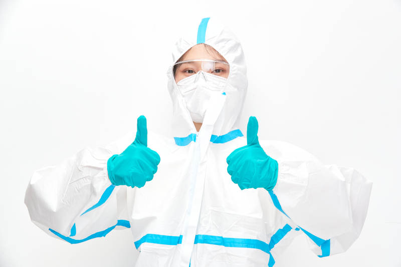 穿白色防护服佩戴护目镜口罩的女性医疗人员图片