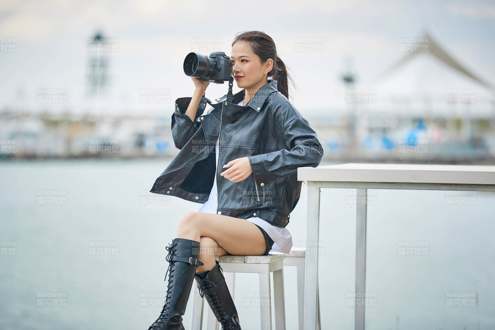 户外湖畔进行拍摄的亚洲青年女性摄影师图片