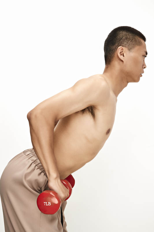 使用哑铃进行健身锻炼的亚洲男性图片
