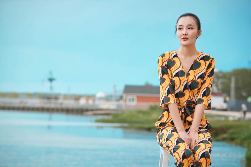 悠闲的坐在美丽湖岸码头的亚洲年轻女性人像图片