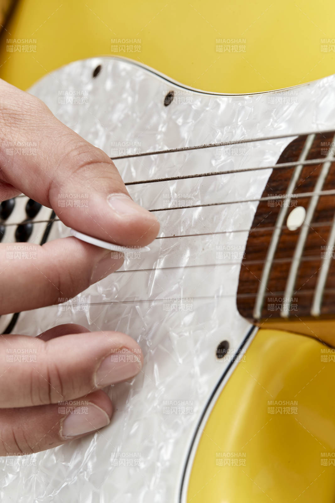 示范演奏摇滚电吉他的亚洲男性乐手人像局部特写图片