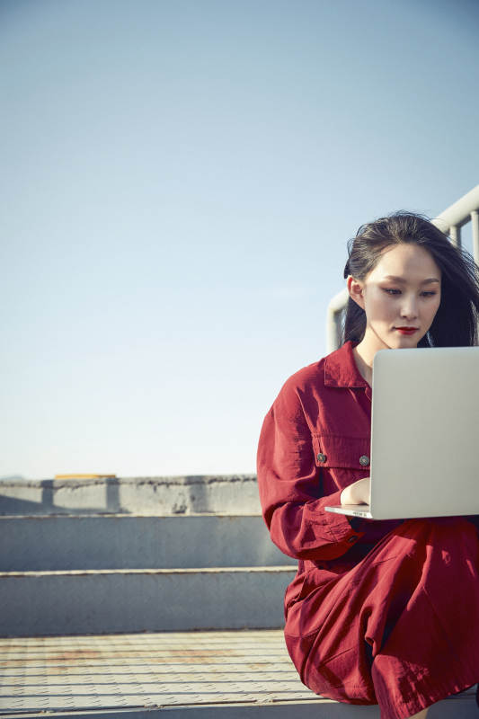 亚洲商务年轻女性在楼顶停机坪使用电脑办公图片