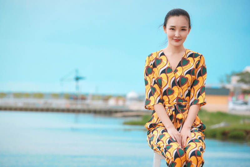 悠闲的坐在美丽湖岸码头的亚洲年轻女性人像图片