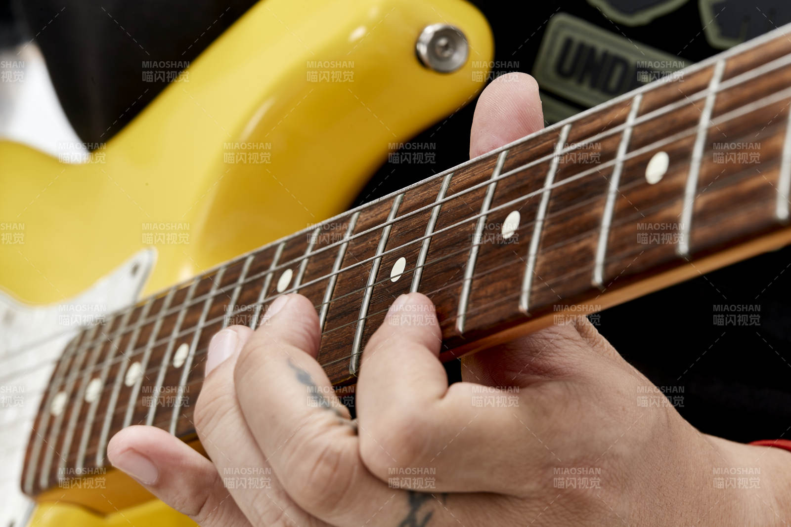 示范演奏摇滚电吉他的亚洲男性乐手人像局部特写图片