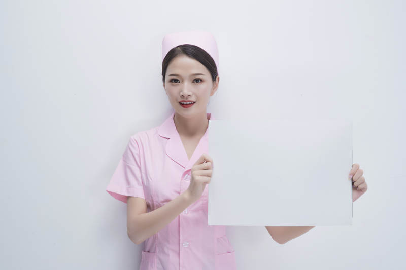 身穿粉色护士服佩戴听诊器的女性医护人员图片