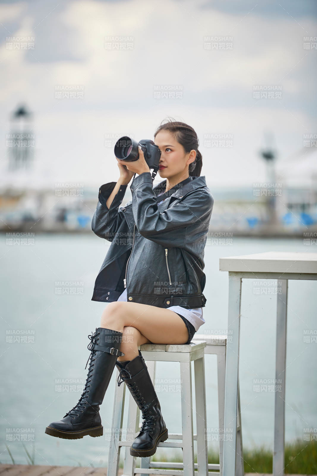 户外湖畔进行拍摄的亚洲青年女性摄影师图片