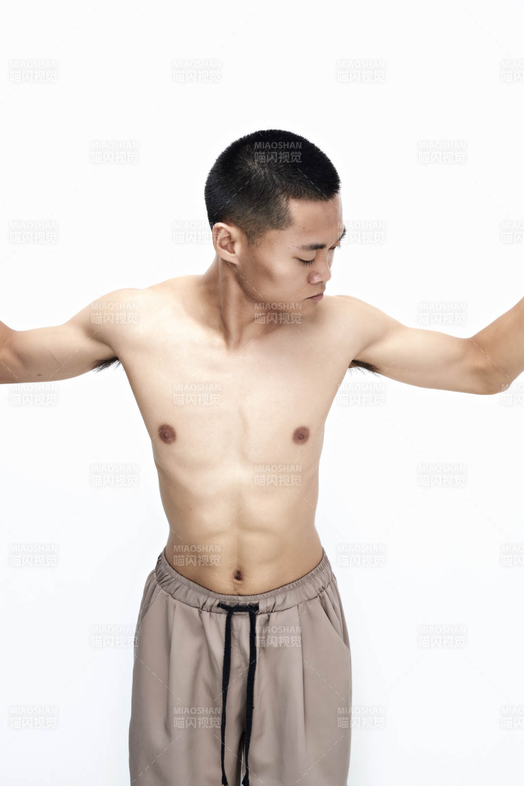 白色背景下展示健身预备拉伸动作的亚洲男性图片