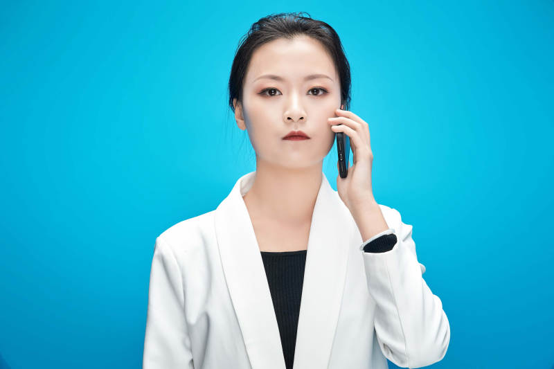 身穿西服拿着手机与文件夹的亚洲商务女士图片