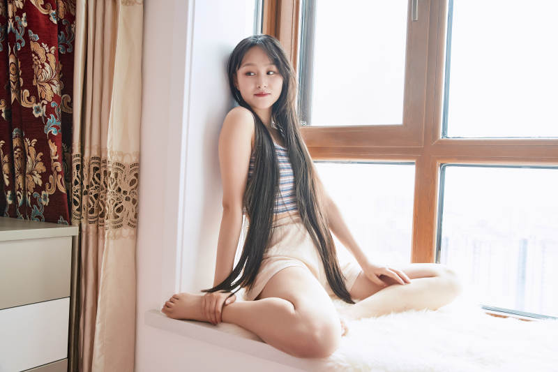 躺在舒适的飘窗上听音乐追剧的亚洲少女图片