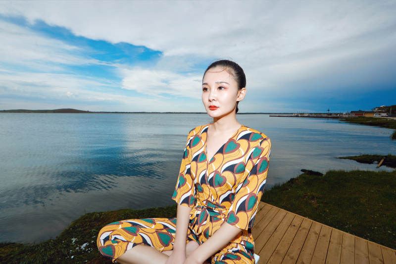 悠闲的坐在美丽湖岸码头的亚洲年轻女性人像图片