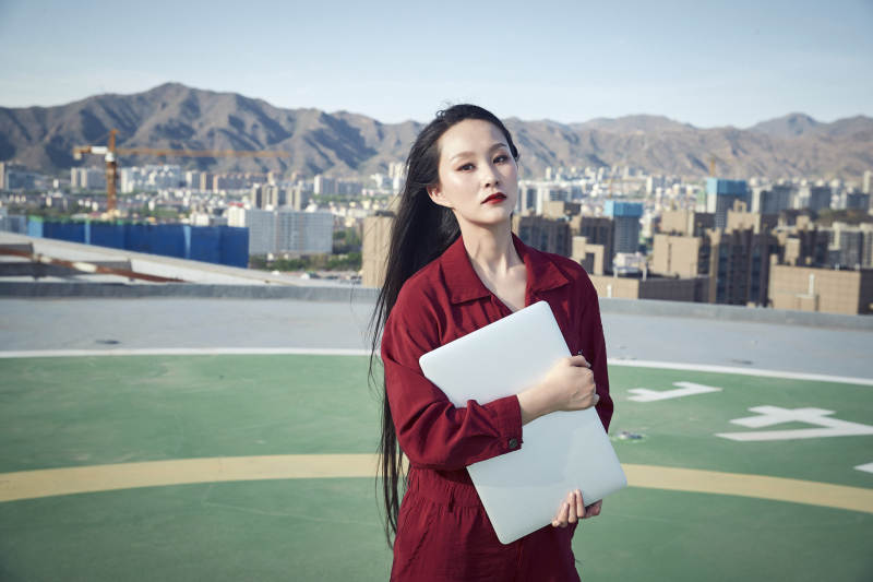 亚洲商务年轻女性在楼顶停机坪使用电脑办公图片