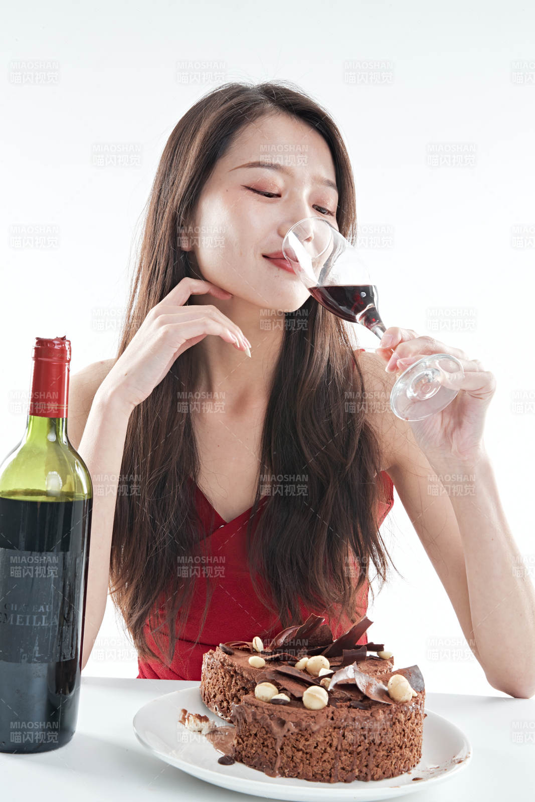 喝红酒品尝蛋糕的年轻女性图片