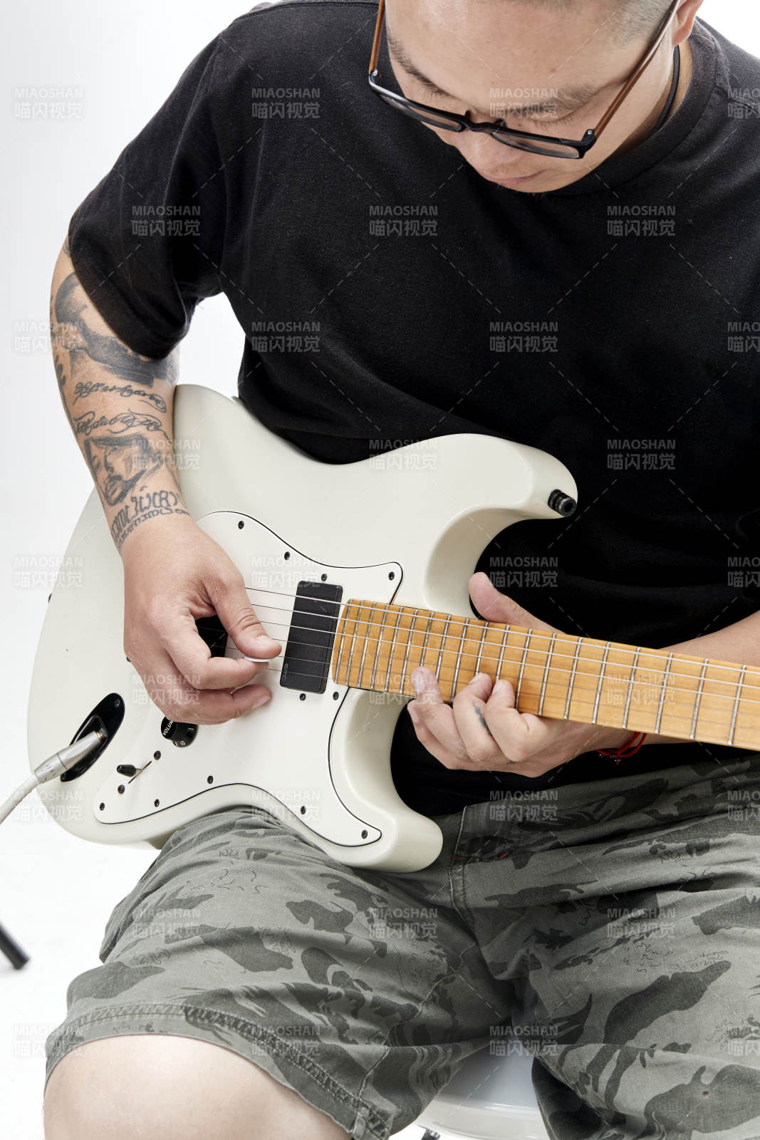 示范演奏摇滚电吉他的亚洲男性乐手人像局部特写图片
