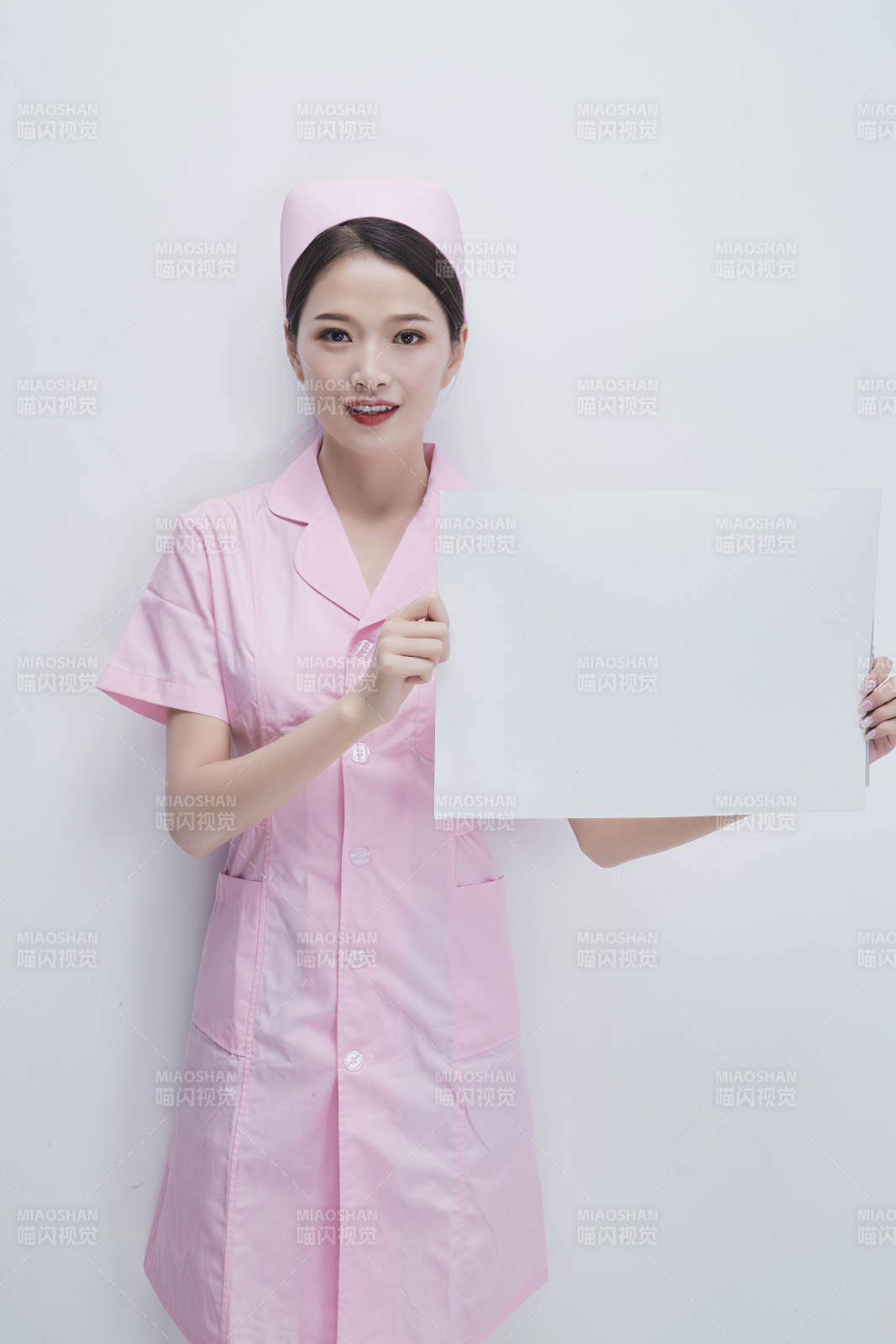 身穿粉色护士服佩戴听诊器的女性医护人员图片