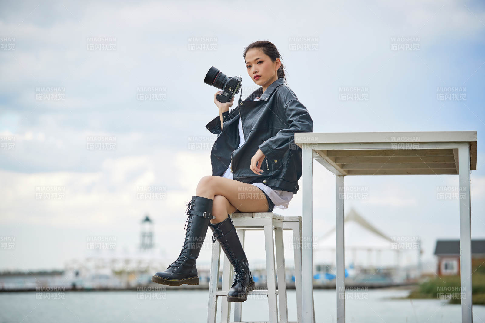 户外湖畔进行拍摄的亚洲青年女性摄影师图片