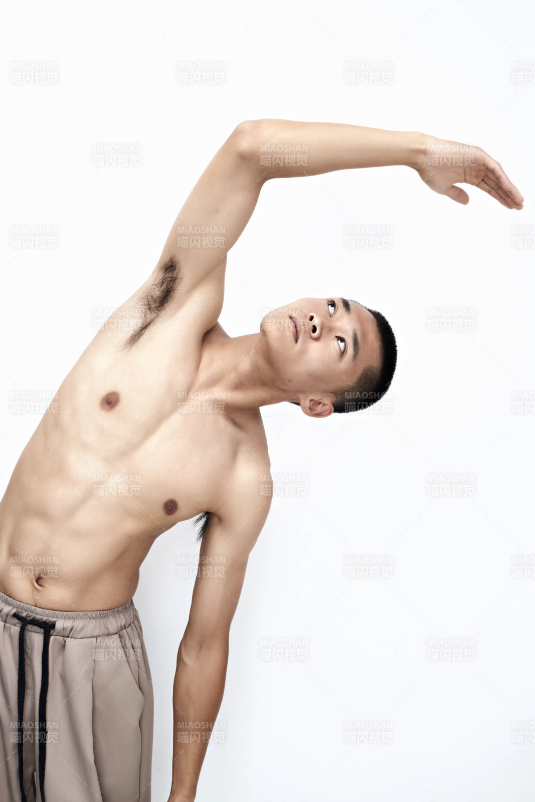 白色背景下展示健身预备拉伸动作的亚洲男性图片