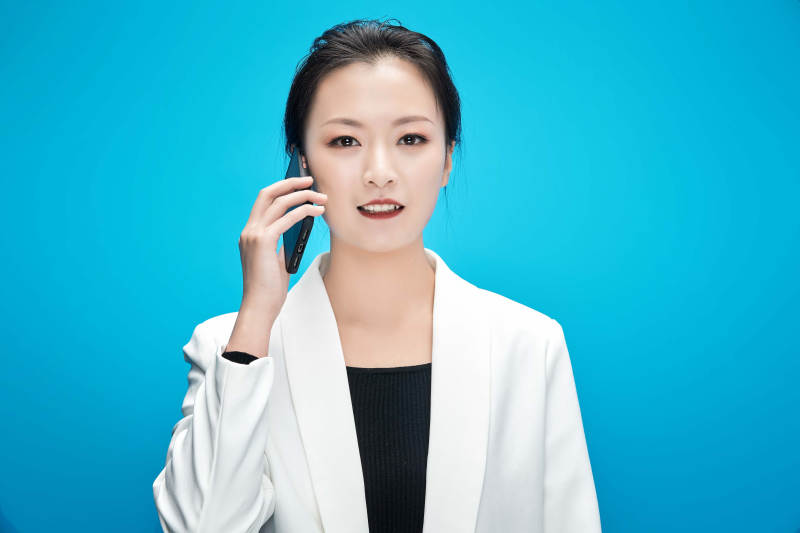 身穿西服拿着手机与文件夹的亚洲商务女士图片