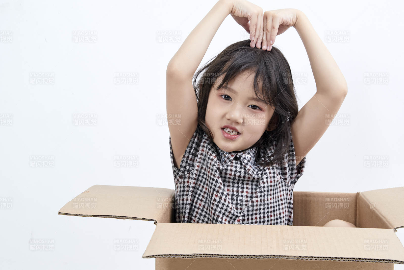 躲在纸箱中玩耍的调皮可爱亚洲小女孩儿童图片