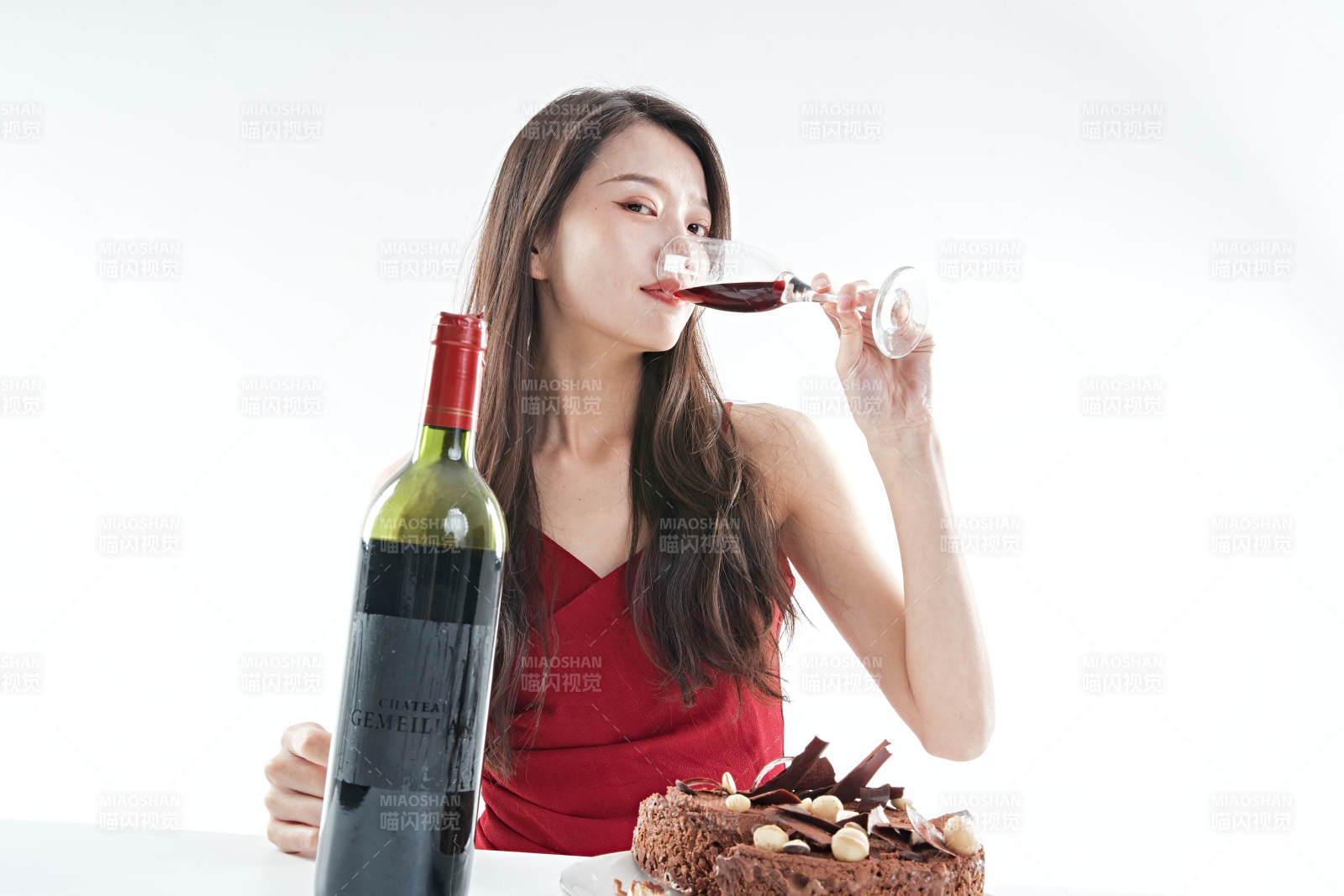 喝红酒品尝蛋糕的年轻女性图片