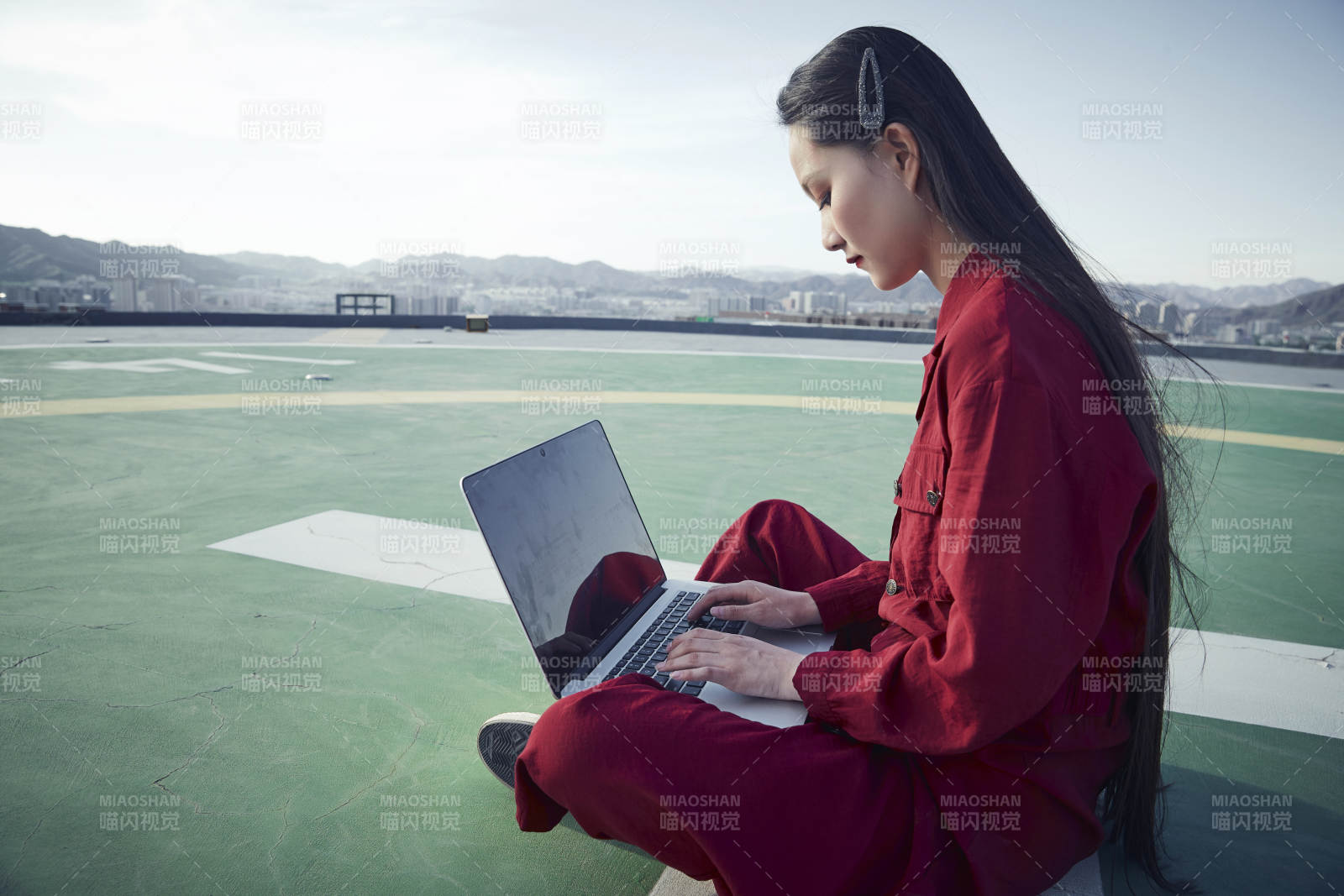 亚洲商务年轻女性在楼顶停机坪使用电脑办公图片