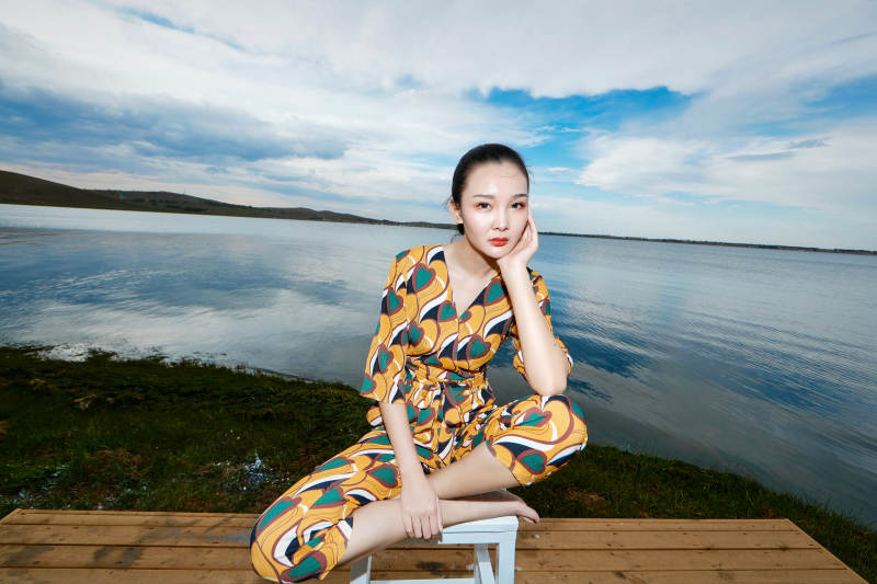 悠闲的坐在美丽湖岸码头的亚洲年轻女性人像图片