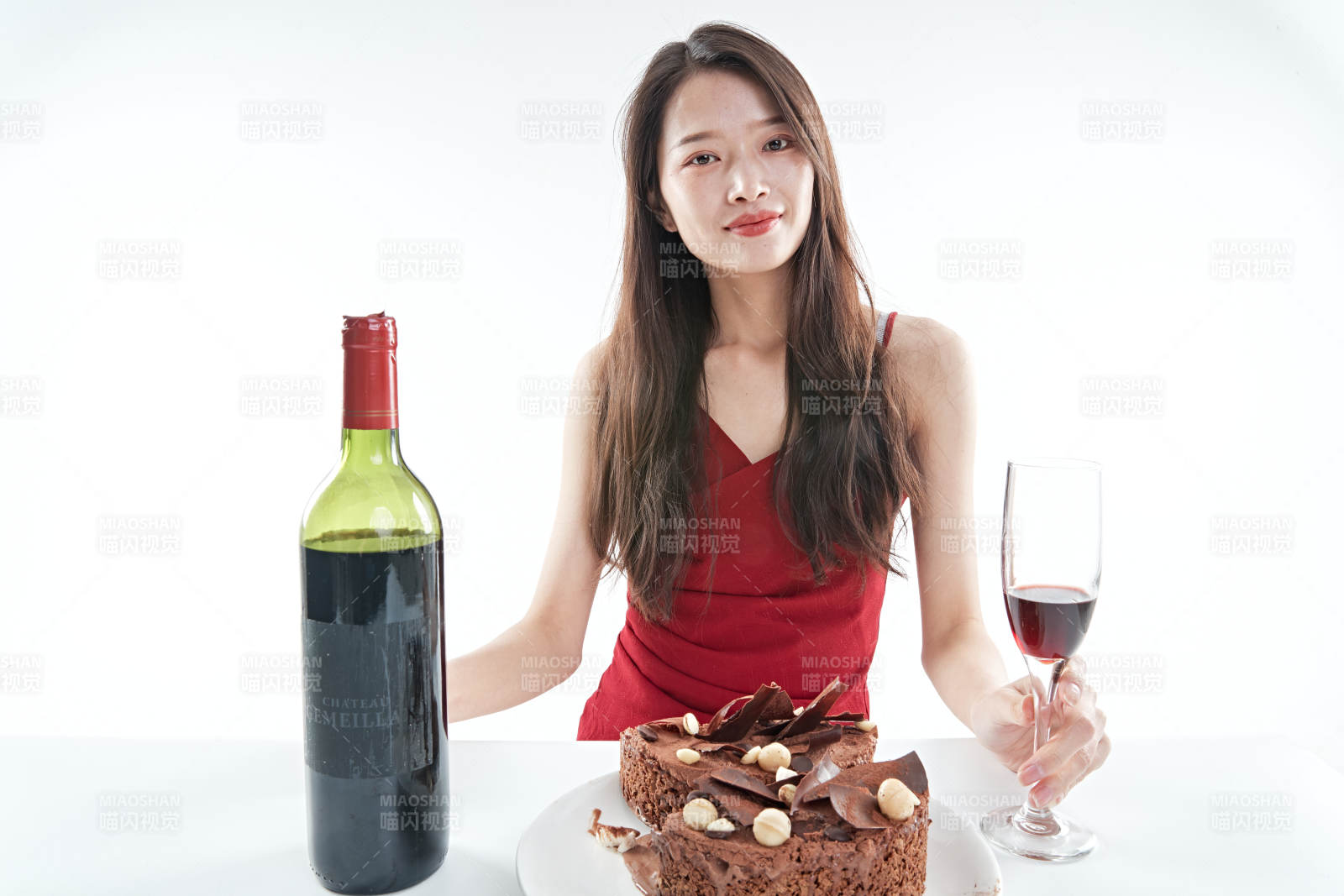 喝红酒品尝蛋糕的年轻女性图片