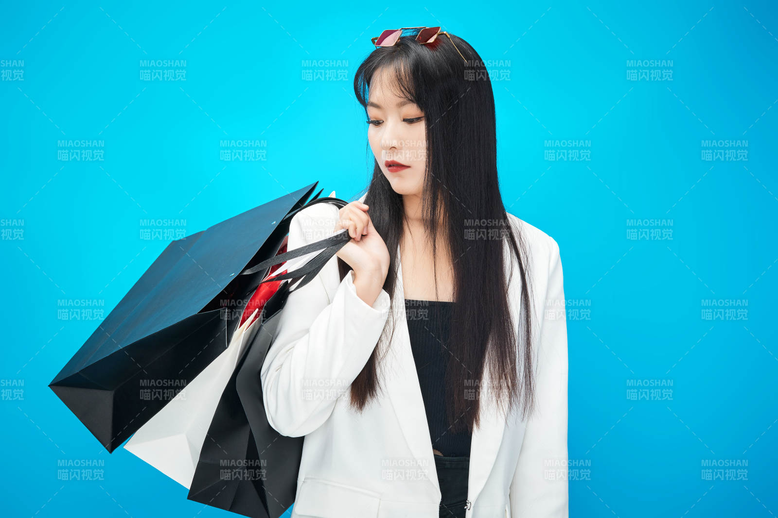 青蓝色背景下手提购物袋的亚洲时尚少女图片