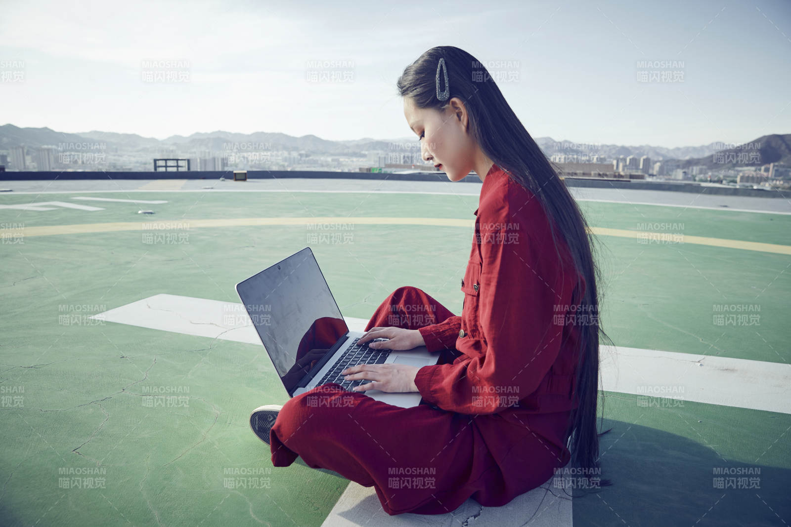 亚洲商务年轻女性在楼顶停机坪使用电脑办公图片