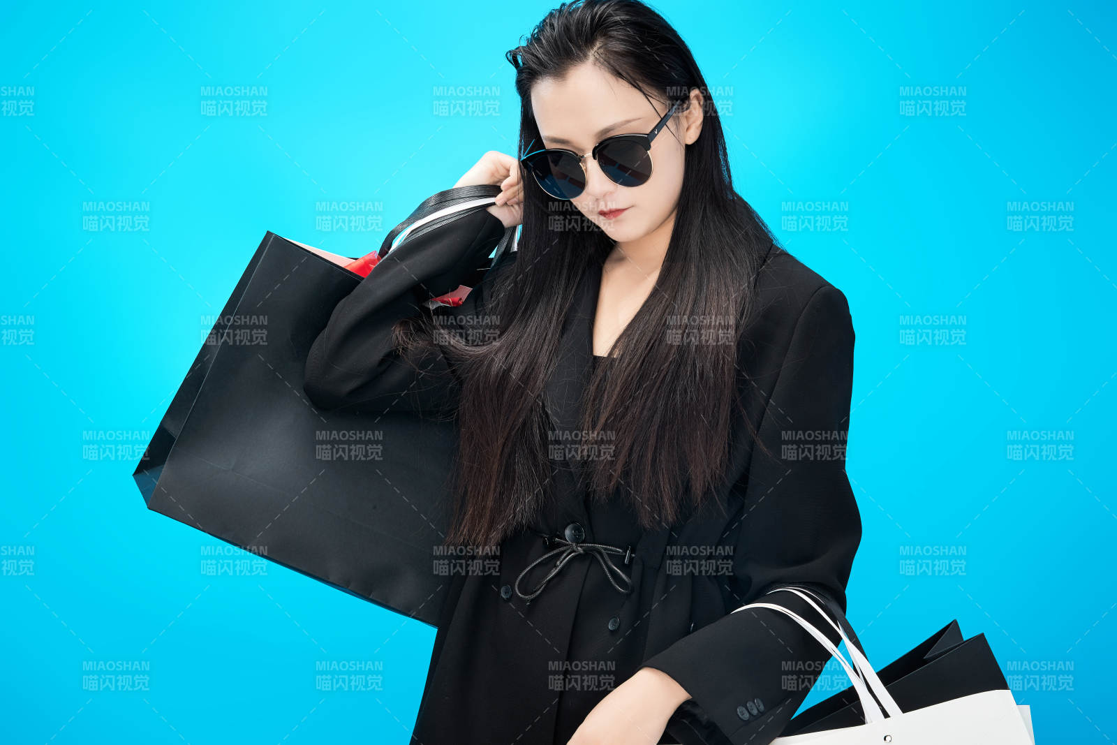 青蓝色背景下手提购物袋的亚洲时尚少女图片