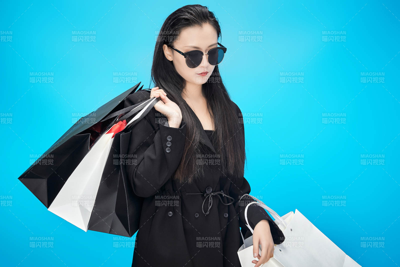 青蓝色背景下手提购物袋的亚洲时尚少女图片