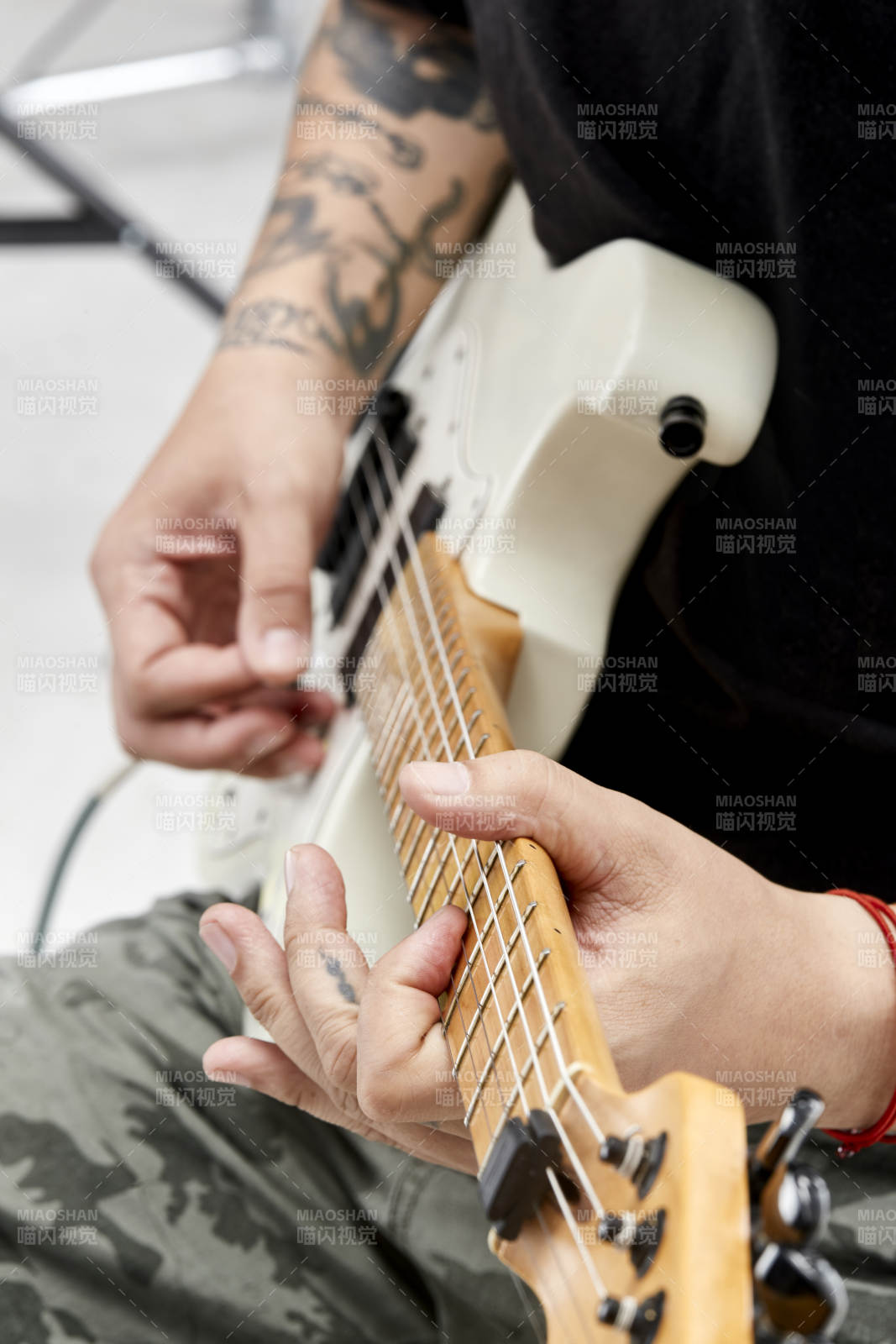 示范演奏摇滚电吉他的亚洲男性乐手人像局部特写图片