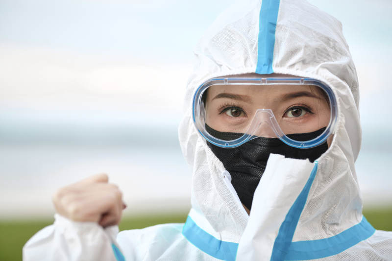 穿白色防护服佩戴护目镜口罩的女性防护人员图片
