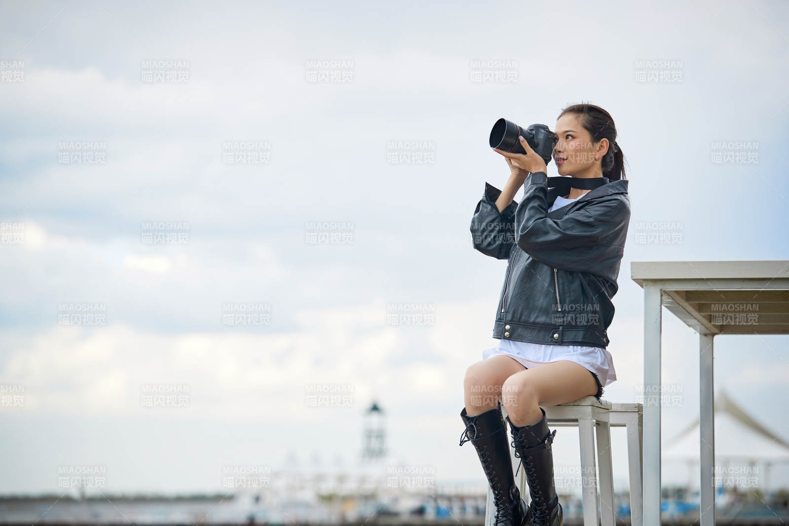 户外湖畔进行拍摄的亚洲青年女性摄影师图片