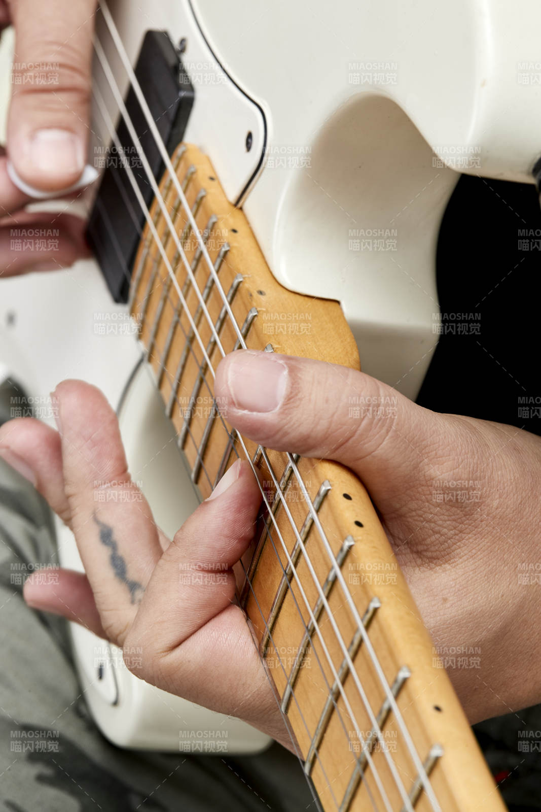 示范演奏摇滚电吉他的亚洲男性乐手人像局部特写图片