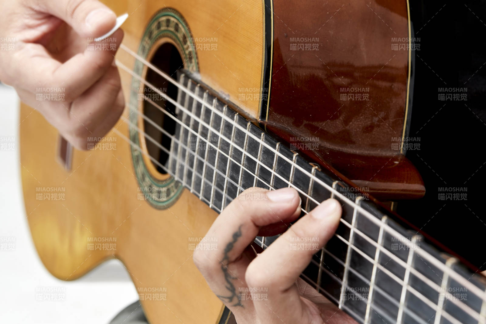 示范演奏古典吉他的亚洲男性乐手人像局部特写图片