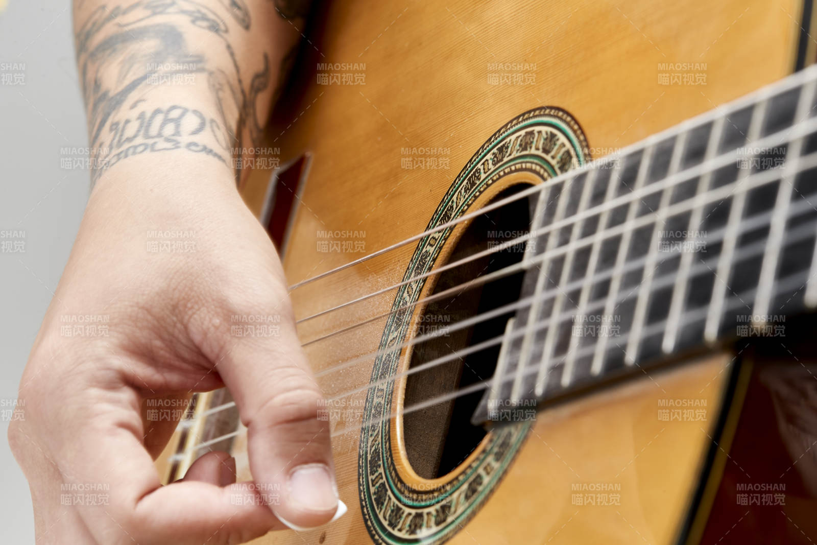示范演奏古典吉他的亚洲男性乐手人像局部特写图片