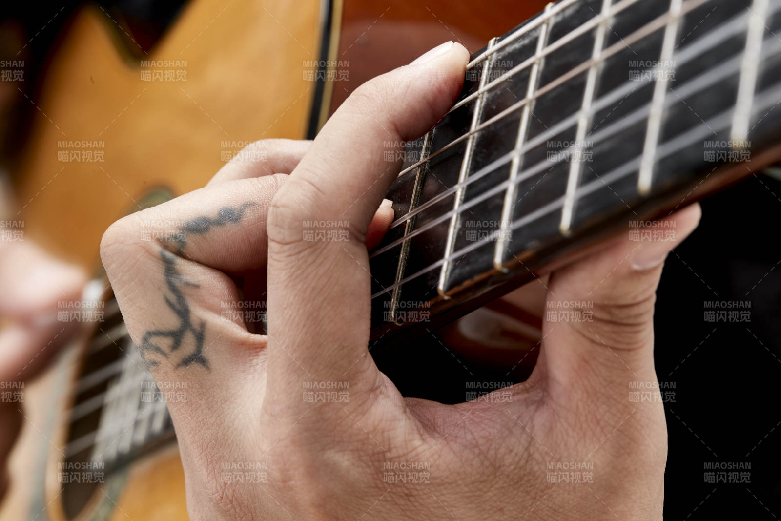 示范演奏古典吉他的亚洲男性乐手人像局部特写图片