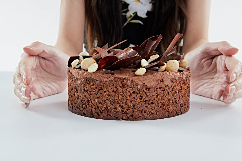 喝红酒品尝蛋糕的年轻女性图片