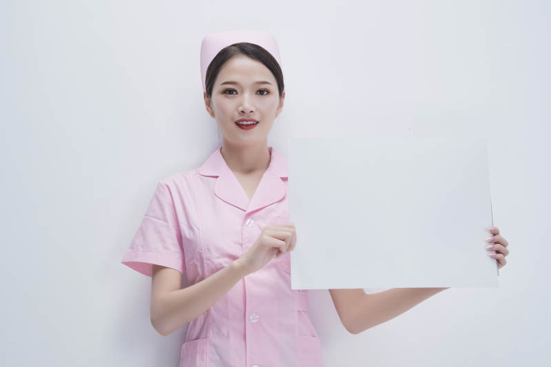 身穿粉色护士服佩戴听诊器的女性医护人员图片