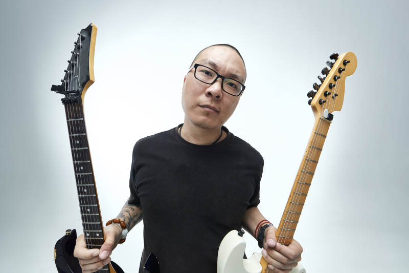 手持电吉他展示演奏的亚洲男性摇滚乐手人像图片