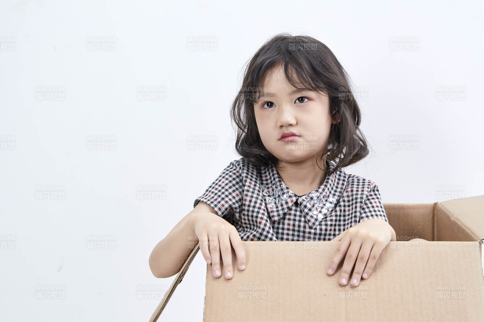 躲在纸箱中玩耍的调皮可爱亚洲小女孩儿童图片