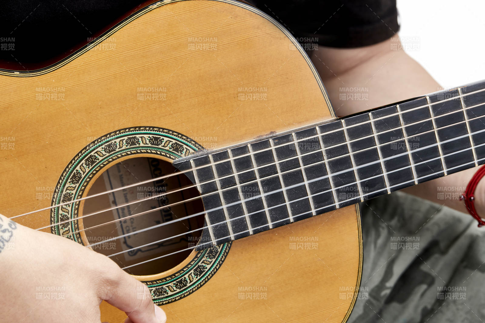 示范演奏古典吉他的亚洲男性乐手人像局部特写图片