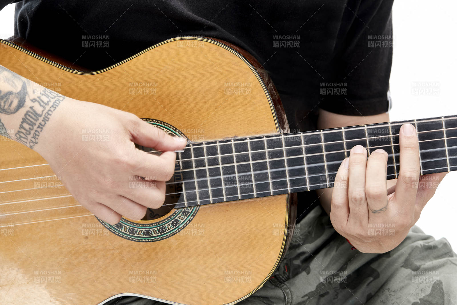 示范演奏古典吉他的亚洲男性乐手人像局部特写图片